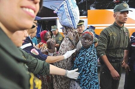 Algerian security forces put migrant women on busses for deportation ©Louiza Ammi/Liberté